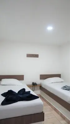 two beds in a hotel room with black robes on them at Hotel Salamanca Resort in Itagüí
