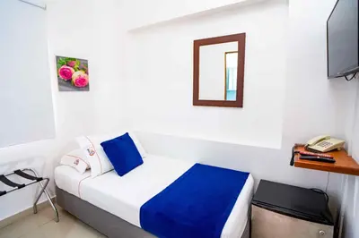 a room with a bed with a phone and a mirror at Hotel Casa 10 in Medellín