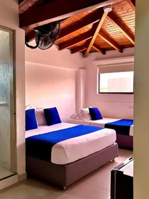 two beds in a room with blue and white at Hotel Casa 10 in Medellín