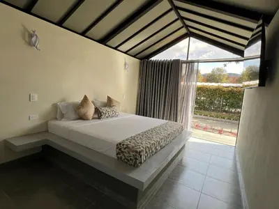 a bed in a room with a large window at STAR CENTER Hotel Boutique in Rionegro