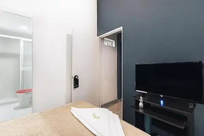 a living room with a flat screen tv and a table at Living Hotel in Medellín