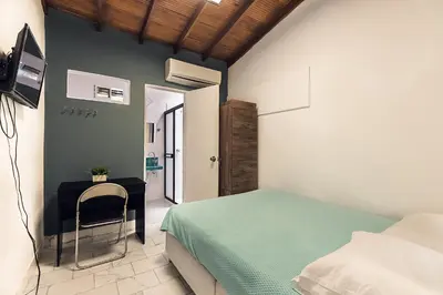 a bedroom with a bed and a table with a chair at Living Hotel in Medellín
