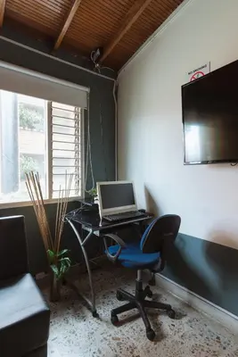 an office with a desk with a laptop computer on it at Living Hotel in Medellín