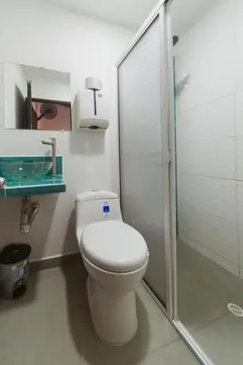 a bathroom with a toilet and a glass shower at Living Hotel in Medellín