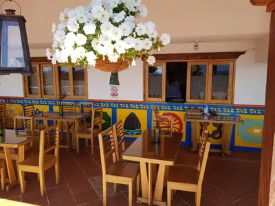 a restaurant with tables and chairs and a chandelier at Hotel Zocalo Campestre in Guatapé