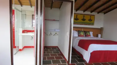 a small bedroom with a bed and a bathroom at Hotel Zocalo Campestre in Guatapé