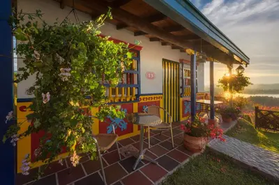 a colorful house with a table and chairs on a patio at Hotel Zocalo Campestre in Guatapé