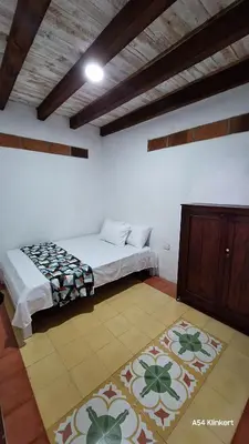 a bedroom with a bed and a cabinet and a rug at Villa Linda ApartaHotel in Jericó