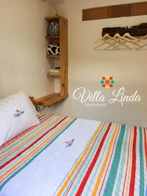 a bedroom with a bed with a colorful striped blanket at Villa Linda ApartaHotel in Jericó