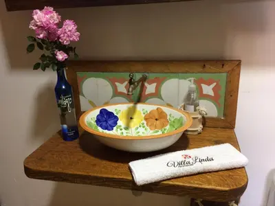 a bowl on a shelf with a vase of flowers at Villa Linda ApartaHotel in Jericó