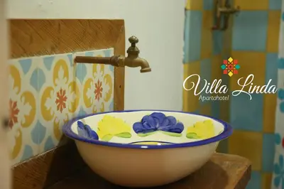 a bathroom sink with a bowl with flowers on it at Villa Linda ApartaHotel in Jericó