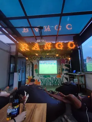a group of people sitting on couches watching a television at Rango Hostel Boutique in Medellín