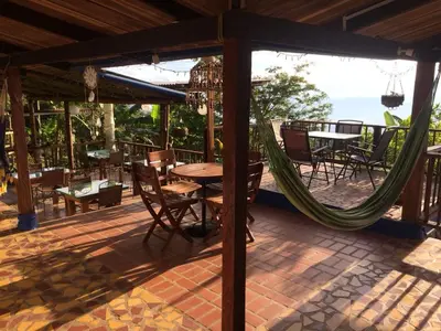 a patio with a table and chairs and a hammock at Monte Mágico in Támesis