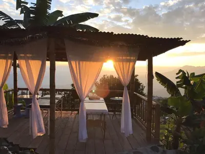 a deck with a bed and a gazebo with the sunset at Monte Mágico in Támesis