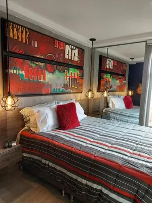 a bedroom with a large bed with red pillows at All Inclusive Suites in Medellín