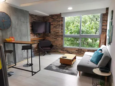 a living room with a couch and a table and a clock at All Inclusive Suites in Medellín
