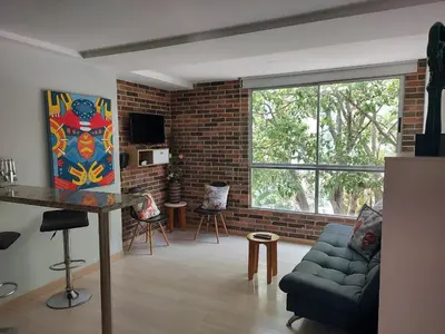 a living room with a couch and a brick wall at All Inclusive Suites in Medellín