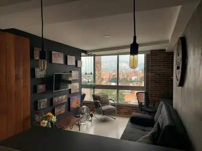 a living room with a couch and a large window at All Inclusive Suites in Medellín