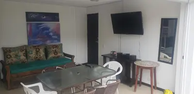 a living room with a couch and a table and chairs at Ciudadela Santafe in Santa Fe de Antioquia