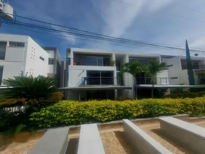 a white building with palm trees in front of it at Ciudadela Santafe in Santa Fe de Antioquia