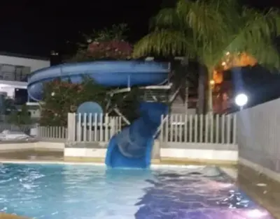 a blue water slide in a swimming pool at night at Ciudadela Santafe in Santa Fe de Antioquia