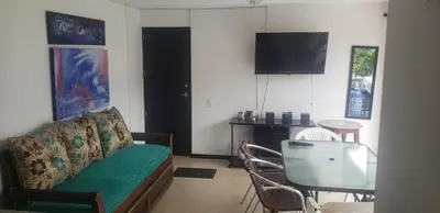 a living room with a couch and a table and a television at Ciudadela Santafe in Santa Fe de Antioquia