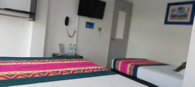 a room with a bed with a colorful blanket at Hotel La Castellana in Manizales