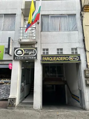 a building with a sign and a flag on it at Hotel Royal Suite in Manizales