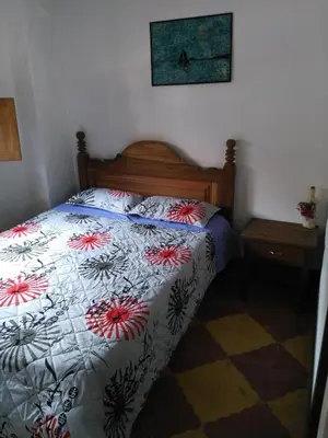 a bedroom with a bed with a floral comforter at Sergeant Pepper's Hostel in Jardin