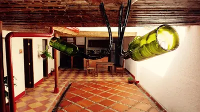 a large green glass bottle hanging from a wall at Sergeant Pepper's Hostel in Jardin