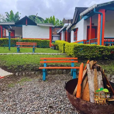 a park with two benches and a basket of logs at Hotel Dulce Campestre in Jardin
