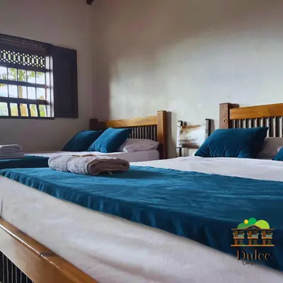 two beds in a bedroom with blue and white sheets at Hotel Dulce Campestre in Jardin