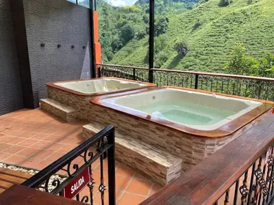 a jacuzzi tub on a balcony with a view at Hotel Dulce Campestre in Jardin