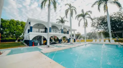 a villa with a swimming pool and palm trees at Arena de Santa Fe by Bernalo Hotels in Santa Fe de Antioquia