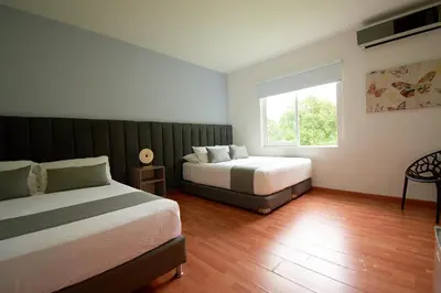 a bedroom with two beds and a window at Arena de Santa Fe by Bernalo Hotels in Santa Fe de Antioquia