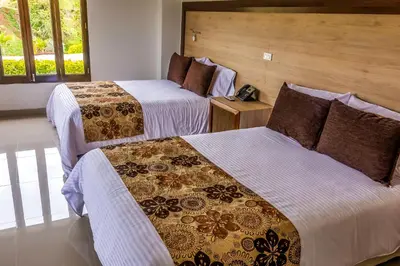 a hotel room with two beds and a telephone at Hotel La Magdalena in Guatapé