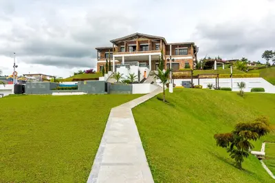 a house on a grassy hill with a walkway at Hotel La Magdalena in Guatapé