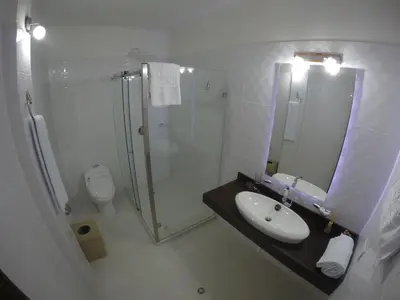 a bathroom with a shower and a sink and a toilet at Hotel La Magdalena in Guatapé