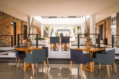 a dining room with two tables and chairs and a mirror at Hotel La Magdalena in Guatapé