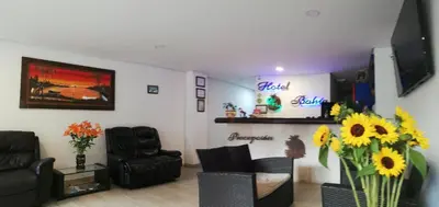 a living room with a couch and chairs and flowers at Hotel Bahia Guatape in Guatapé