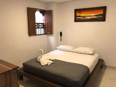 a bedroom with a bed with a swan on it at Hotel Bahia Guatape in Guatapé