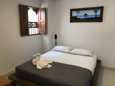 a bedroom with a bed with a stuffed animal sitting on a table at Hotel Bahia Guatape in Guatapé