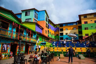 a group of people walking around a street with buildings at Hotel Las Vegas in Guatapé