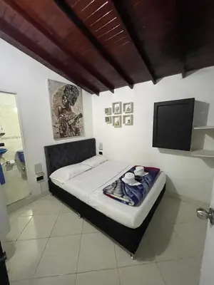 a bedroom with a bed with a flat screen tv at Hotel Las Vegas in Guatapé