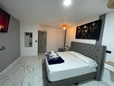 a bedroom with a large bed in a room with marble floors at Hotel Las Vegas in Guatapé