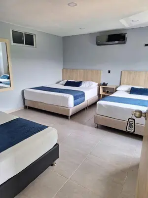 a hotel room with two beds and a television at Hotel Suramericana in Medellín