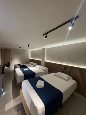 two beds in a hotel room with lights at Hotel Suramericana in Medellín