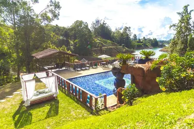 a pool with a waterfall next to a resort at Mansión by Bernalo Hotels in Guatapé