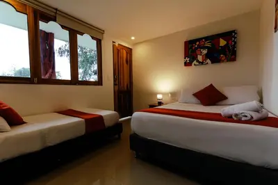 two beds in a room with two windows at Mansión by Bernalo Hotels in Guatapé