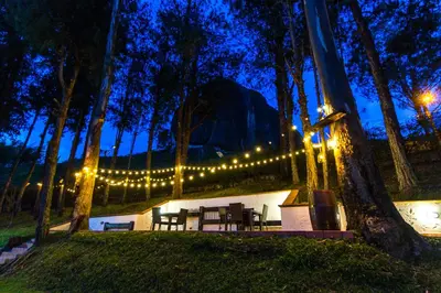 a group of tables and chairs in a park with lights at Mansión by Bernalo Hotels in Guatapé